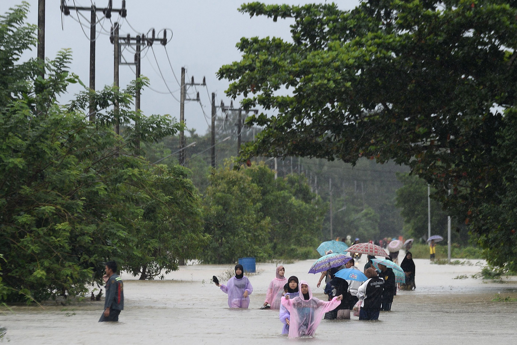 People wade through flooded roads in southern Thailand, Jan. 2021.