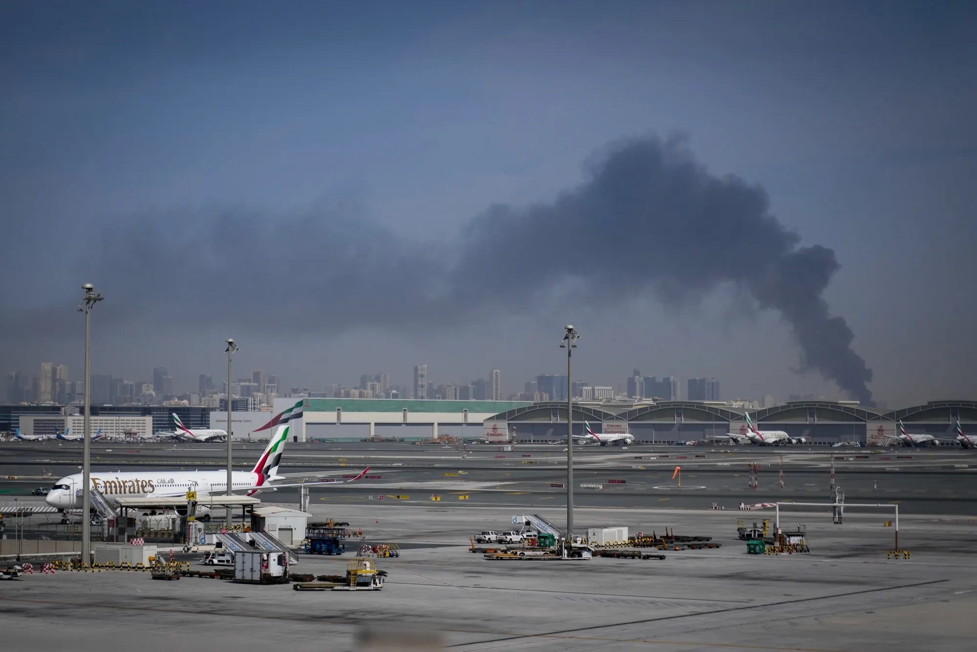 A plume of smoke caused by an Iranian strike beyond Emirates planes at Dubai International Airport after its closure, on March 1.