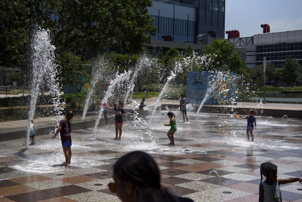 Children play on a splash pad during a heatwave in Houston.
