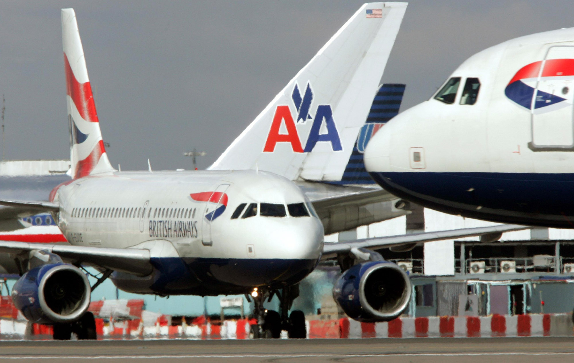 British Airways Airbus taxis pass American Airlines and United Airlines at Heathrow Airport.