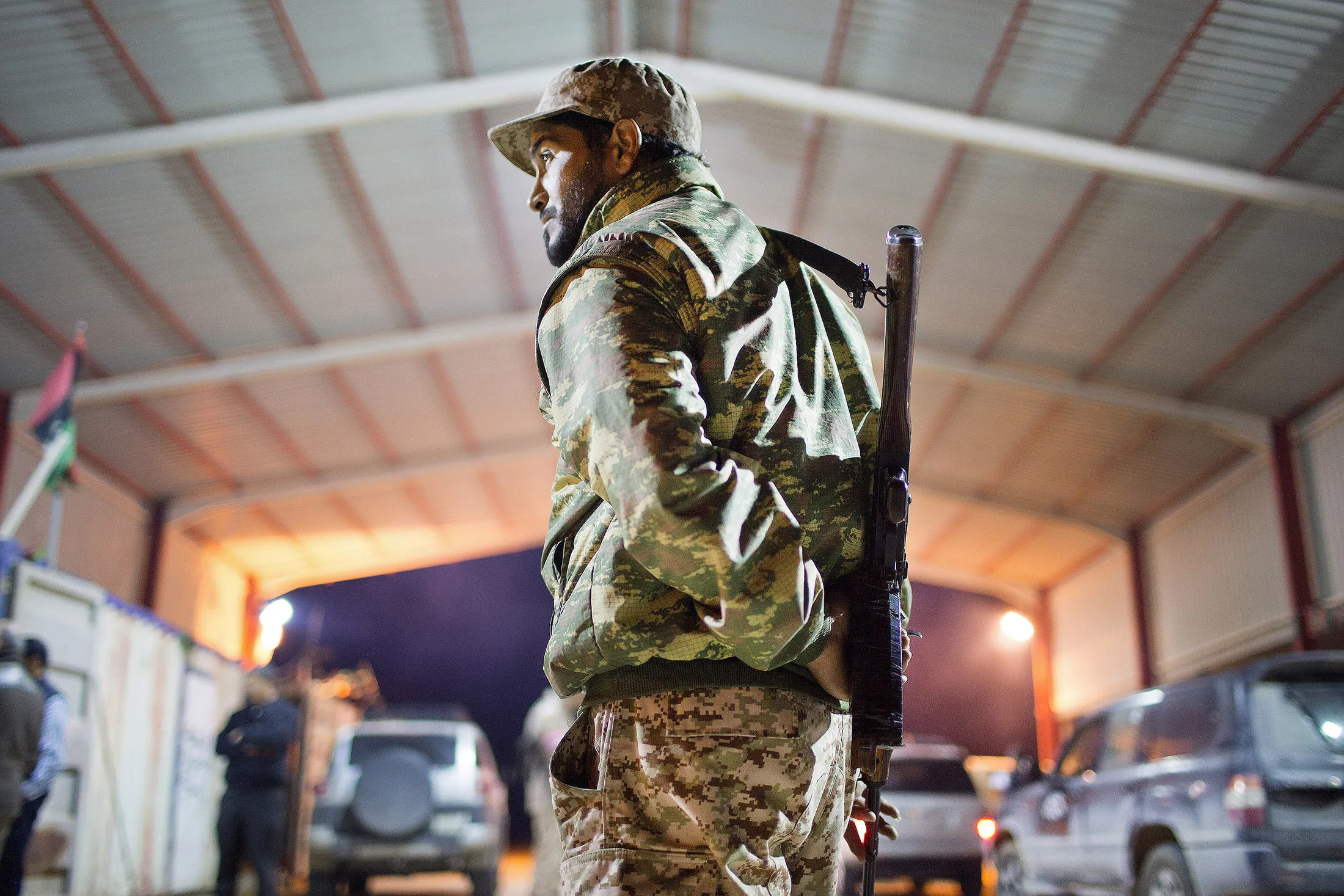 A Libyan military soldier stands guard at the entrance of a town, 110 kilometers (68 miles) from Sirte, Libya.
