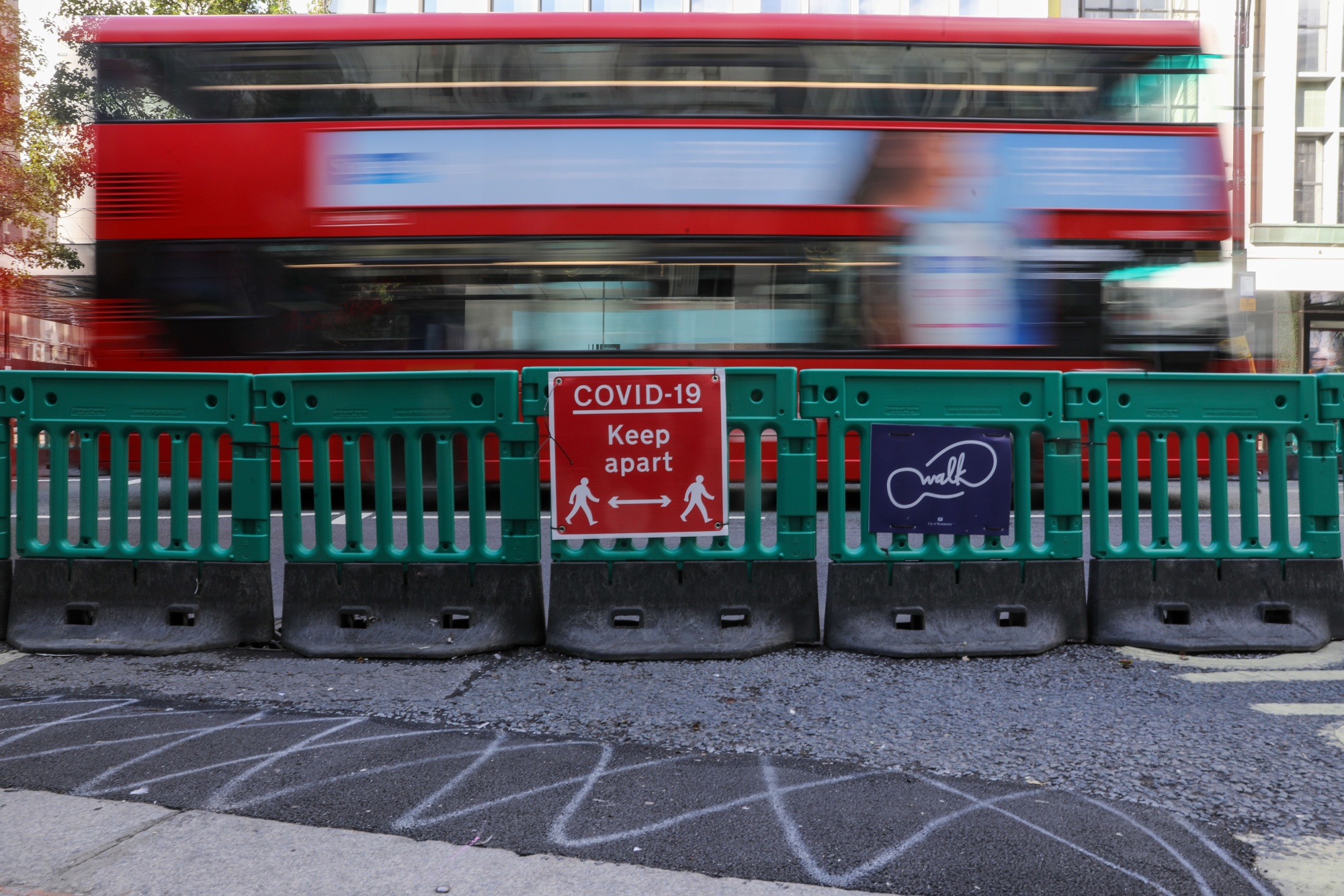 A sign reading &quot;Covid-19 Keep Apart&quot;, sits on a temporary protective pedestrian barrier on Oxford Street in central London, U.K., on Oct. 1.