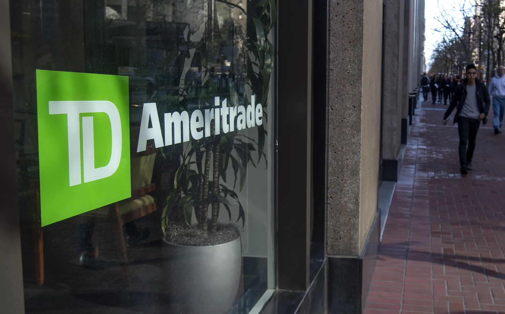 Pedestrians pass in front of a TD Ameritrade Holding Corp. location in San Francisco.