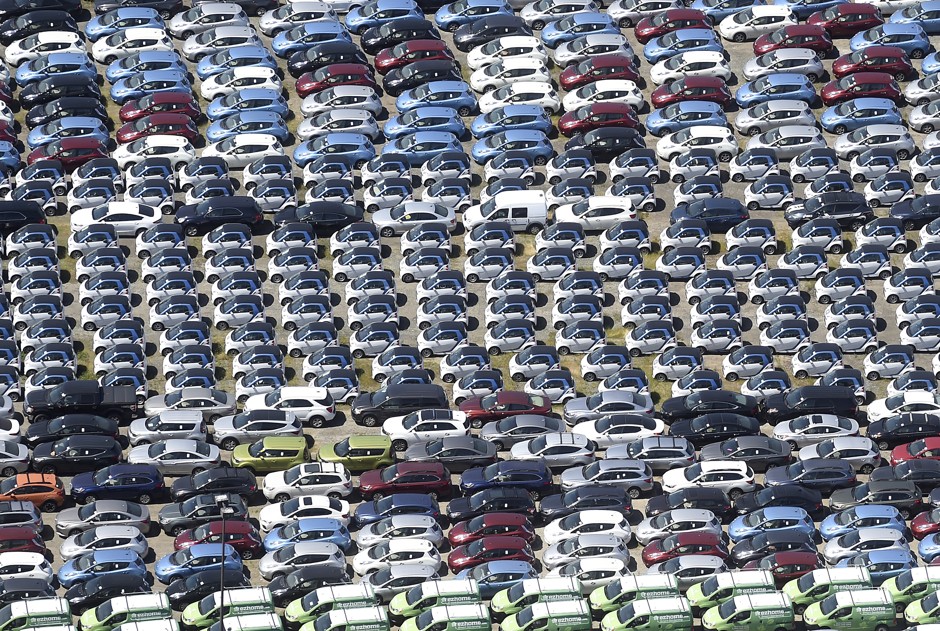 Nissan Leafs, Smart Cars, and other vehicles line in a lot in Hayward, California.