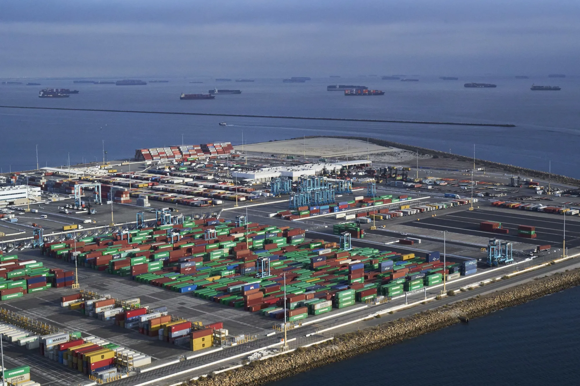 Containers await transport at the Port of Long Beach this week as cargo ships sit moored off the coast of Long Beach, California