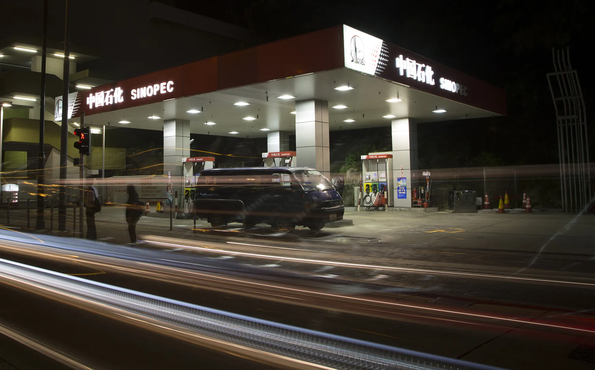 Light trails from passing traffic are seen in front of at a Sinopec&nbsp;gas station&nbsp;in Hong Kong.