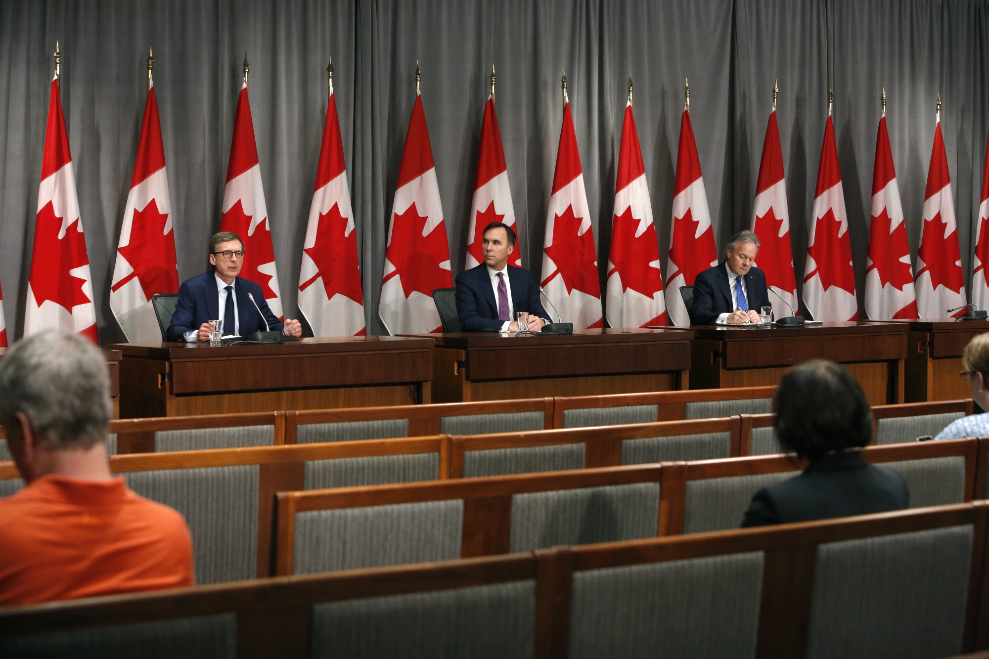 Tiff Macklem, left, speaks at an Ottawa news conference announcing his appointment alongside Bill Morneau and Stephen Poloz on May 1, 2020.