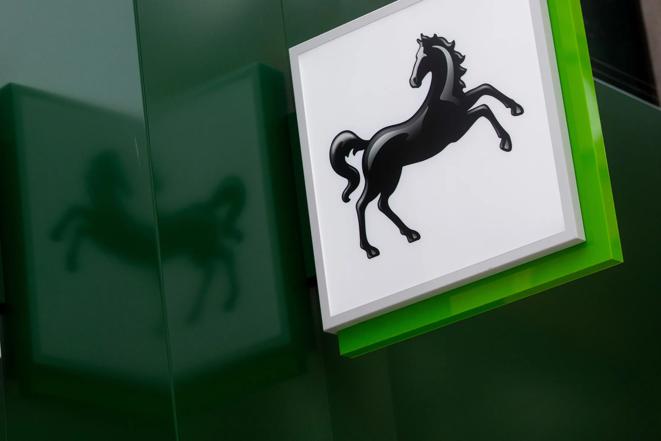 The Lloyds' prancing horse logo sits on signs hanging outside a Lloyds Bank branch, a unit of Lloyds Banking Group Plc, in London, U.K., on Thursday, July 28, 2016.
