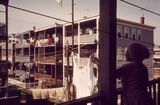 Woman Hangs Laundry at Her Home at 39 Neptune Road at Her Right are Frankfort Street Homes - triple decker homes Boston in 1970s
