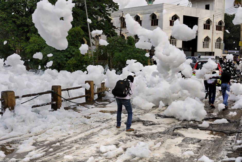 A pedestrian walks among clouds of toxic foam in Bangalore, India.