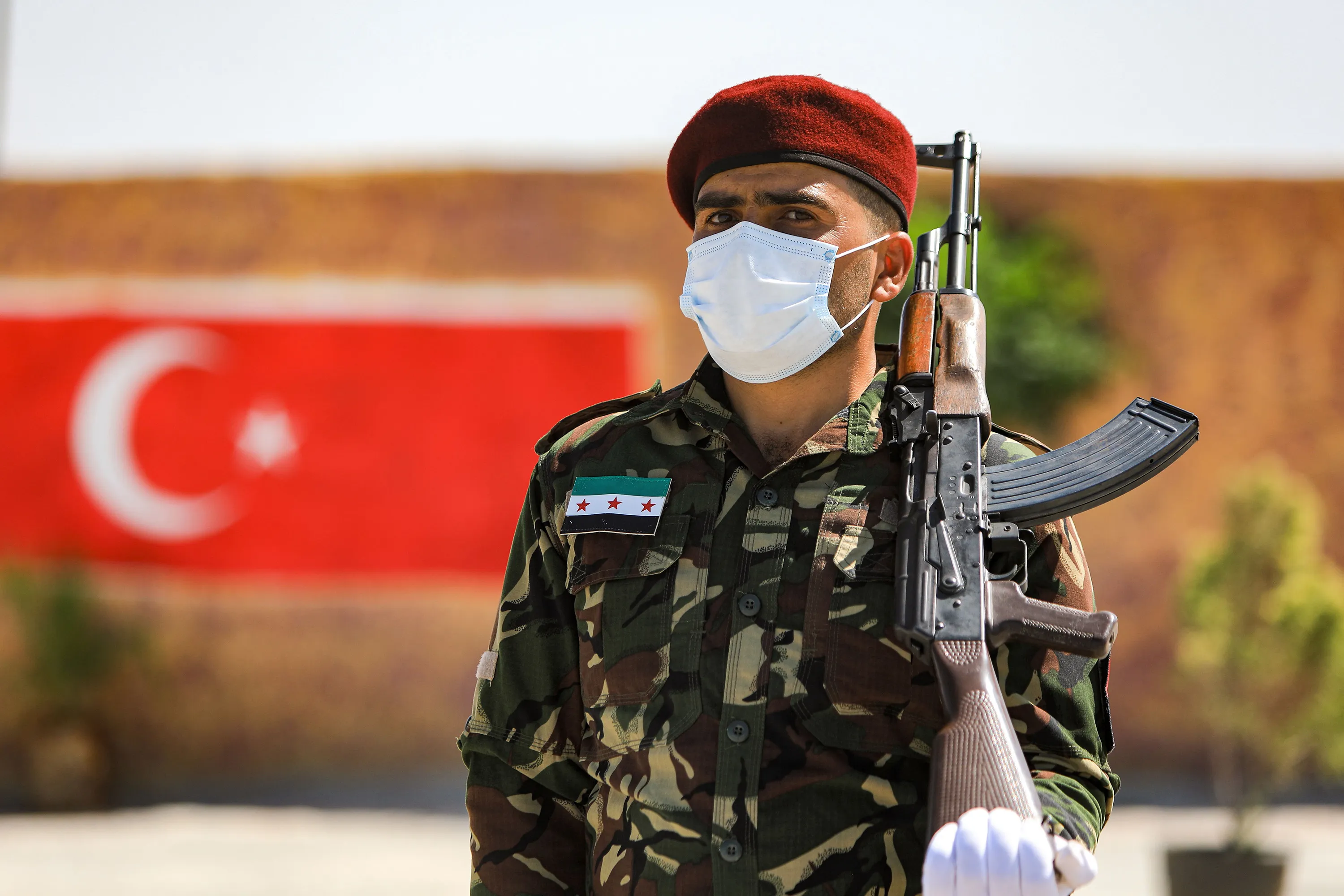 A Turkish-backed Syrian rebel fighter carryies an assault rifle during a military parade in Aleppo province, on Sept. 20.