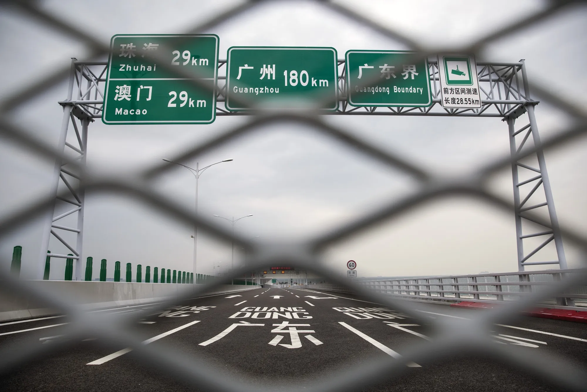 Road signs stand behind a fence near the border with China on the Hong Kong Link Road section of the Hong Kong-Zhuhai-Macau Bridge in Hong Kong.