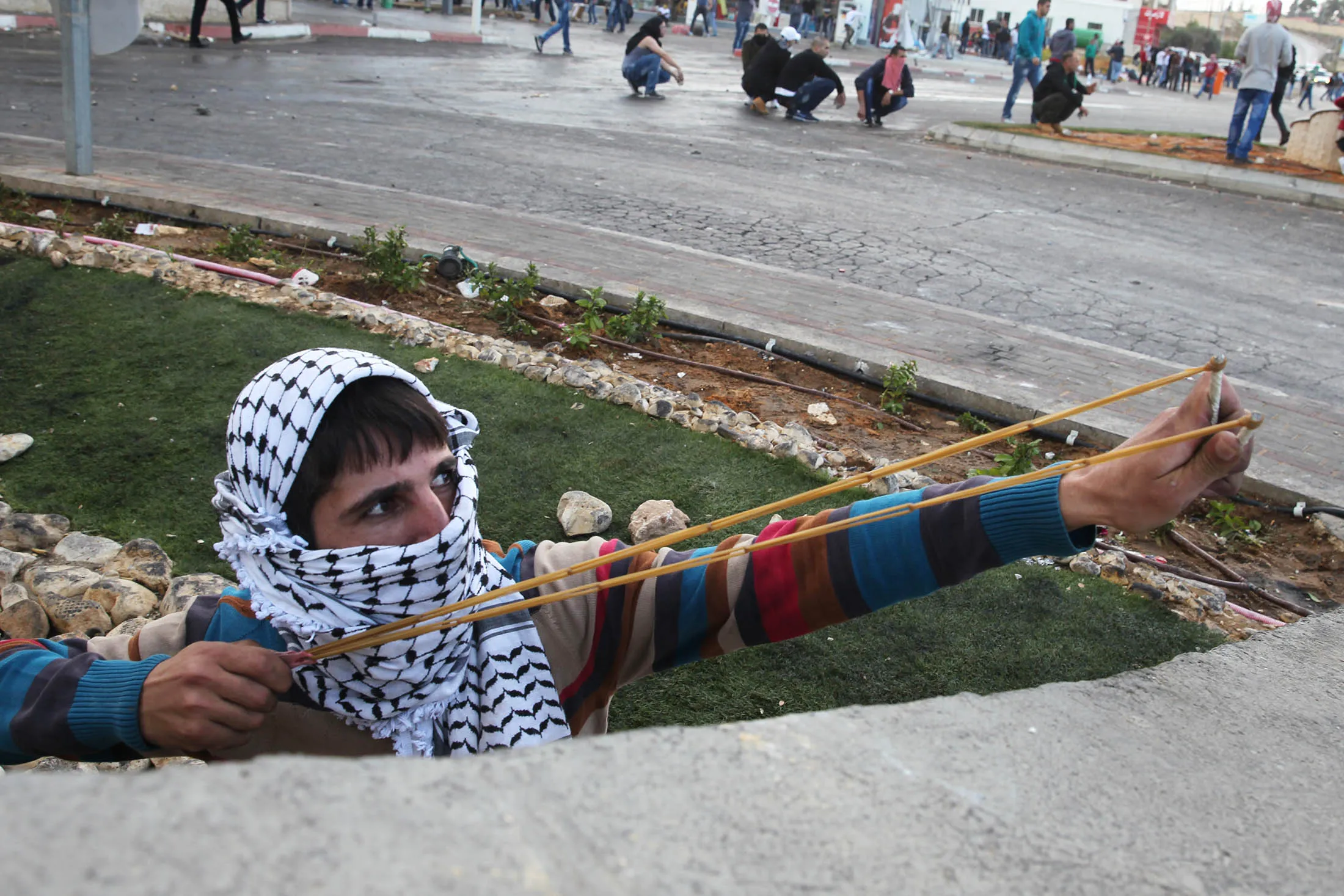 A Palestinian protester uses a slingshot to throw stones during clashes with Israeli security forces in the occupied West Bank, on Oct. 9.
