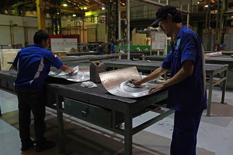 Workers handle Airbus A350 components. Image: Dimas Ardian/Bloomberg