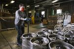 A worker at the Fort Point Beer brewery in San Francisco pushes a pallet of kegs that couldn’t be sold to restaurants.