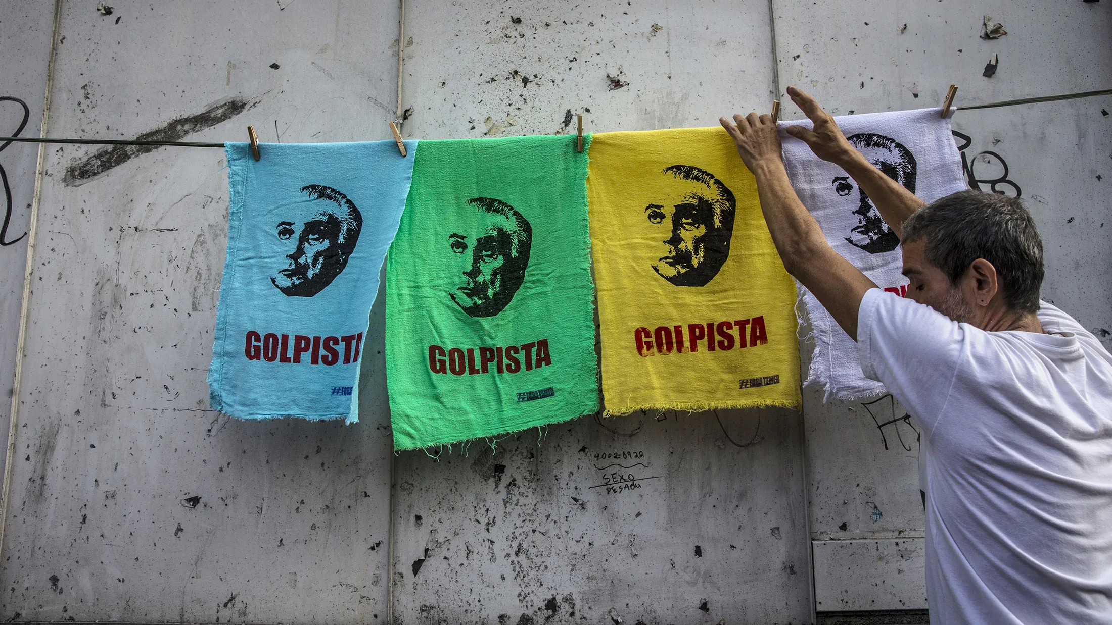 A man hangs rags for sale depicting president Michel Temer during a protest against austerity measures in Rio de Janeiro on March 15, 2017.
