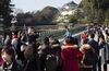 A tour guides speaks to Chinese tourists in the grounds of the Imperial Palace in Tokyo, Japan.
