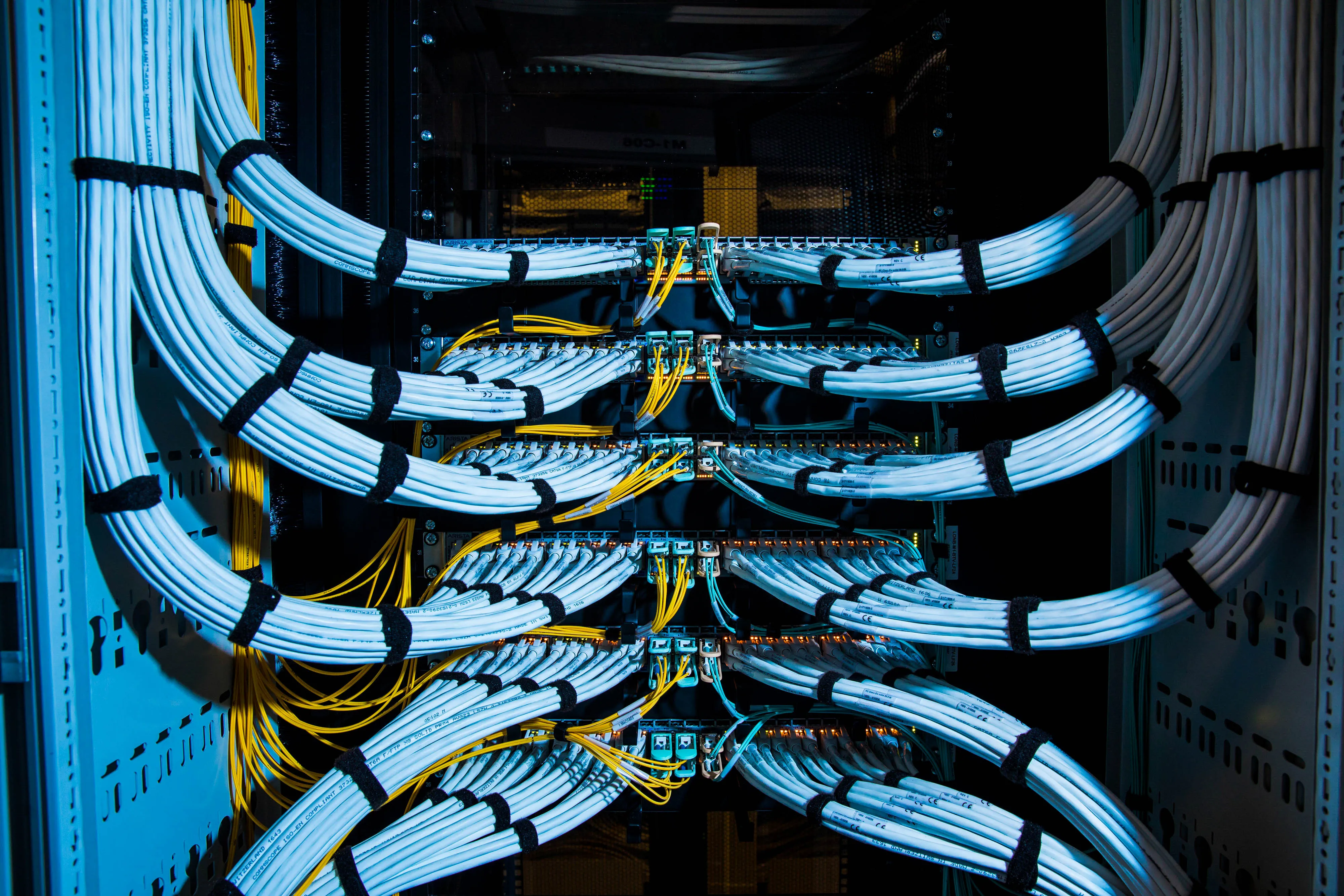 Fiber optic cables, center, and copper Ethernet cables feed into switches