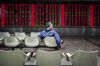 A man sits in front of an electronic board displaying share prices at a securities brokerage in Beijing, China, on Monday, March 7, 2016. Chinese small-cap stocks rallied after Premier Li Keqiang failed to mention a planned shift to a more market-based system for initial public offerings, a reform seen luring funds from existing equities.