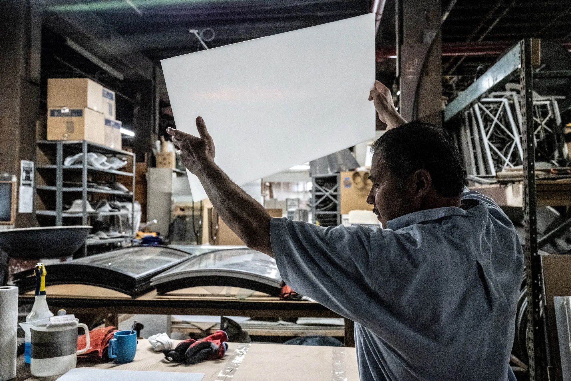 A worker looks at the opacity of a piece of glass at a glassworks in&nbsp;New York.