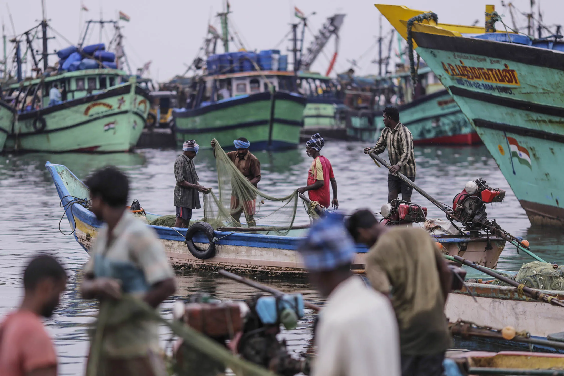 Fishermen tend to their nets near the Kasimedu fish market at the Royapurum fishing harbour in Chennai, India.

