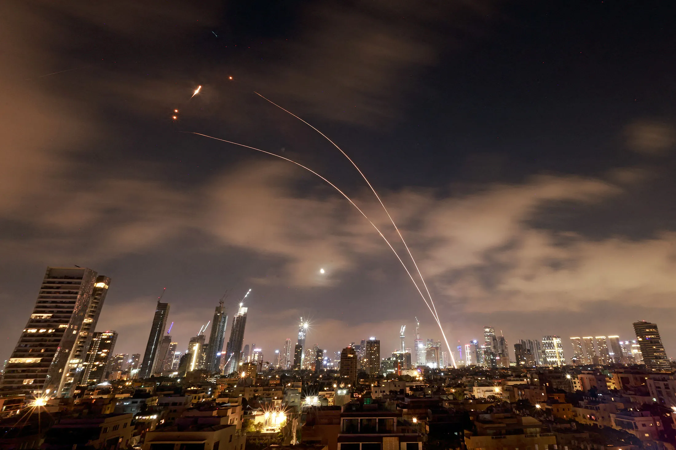 Israeli air defense systems intercept Iranian missiles over Tel Aviv early on June 18.