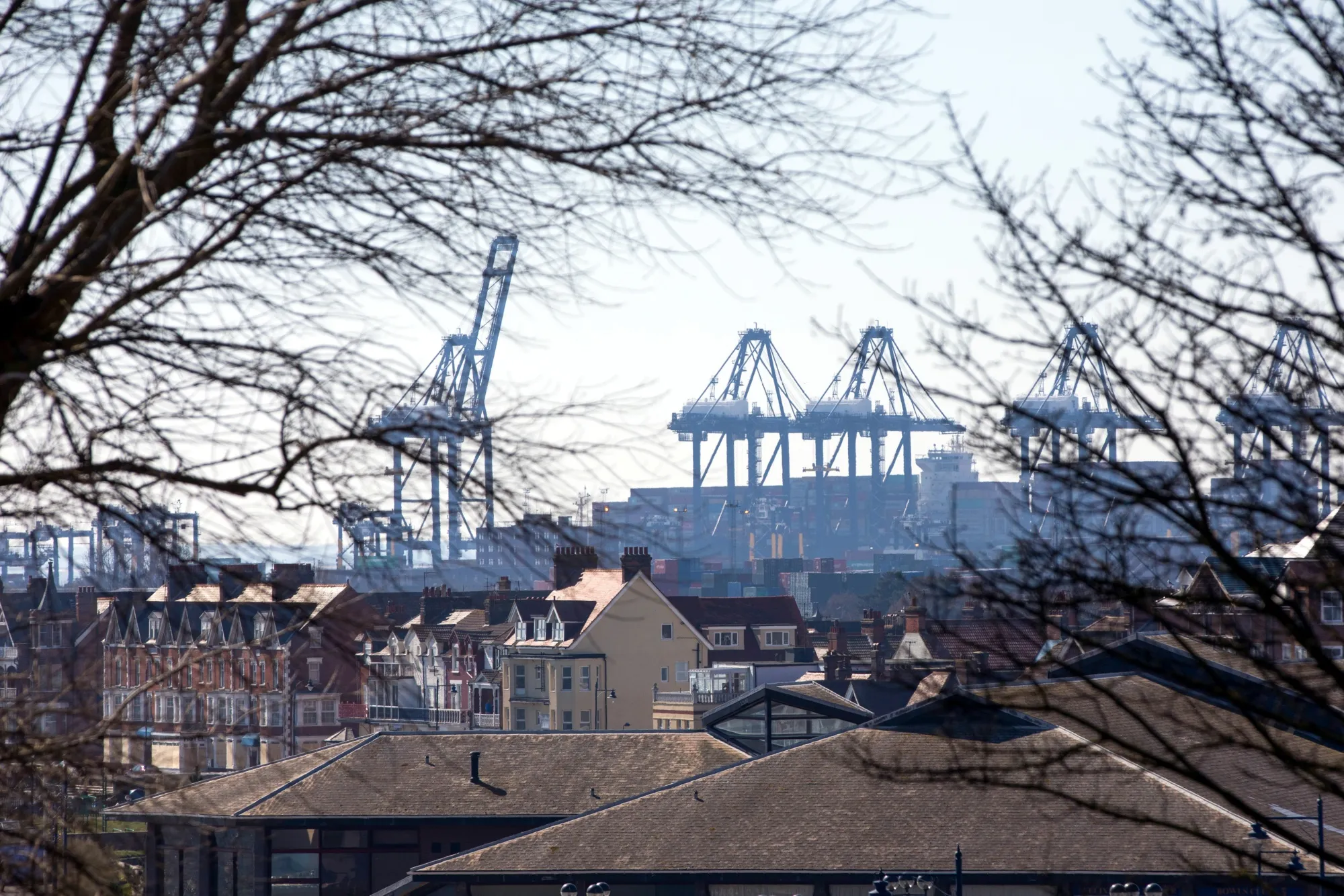 Cranes stand beyond rooftops in Felixstowe, U.K.