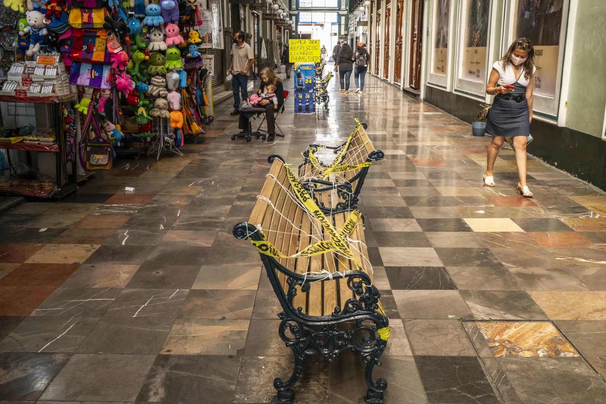 Public benches blocked off with caution tape in Puebla, Mexico.