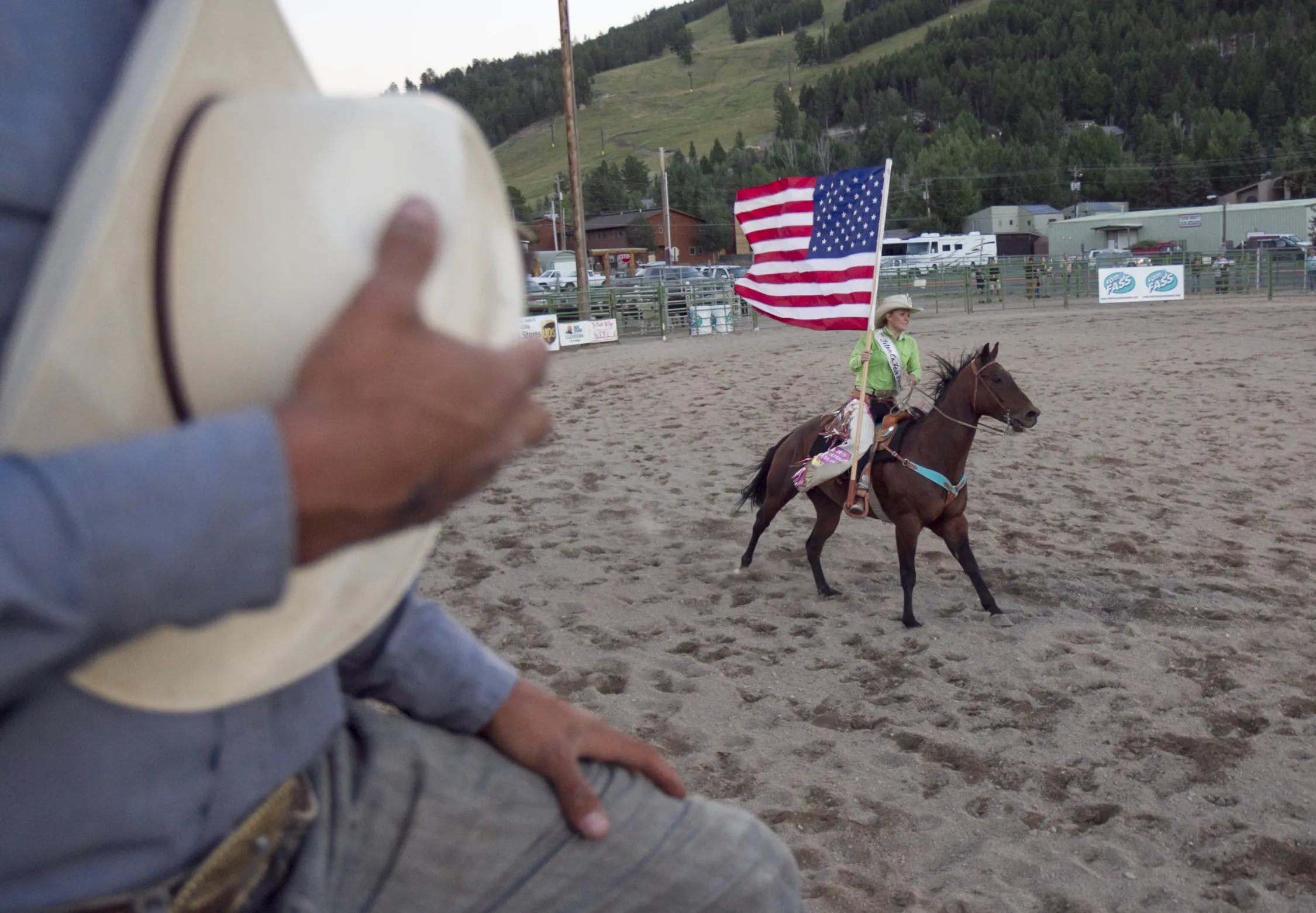 A cowgirl rides with the U.S. flag during the national anthem at the Jackson Hole rodeo in Jackson Hole, Wyoming, U.S.