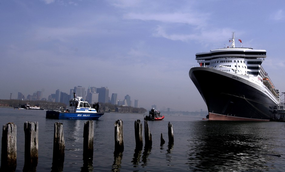 Police and fire boats, the Lower Manhattan skyline and the Brooklyn Bridge are all dwarfed by the Queen Mary 2.