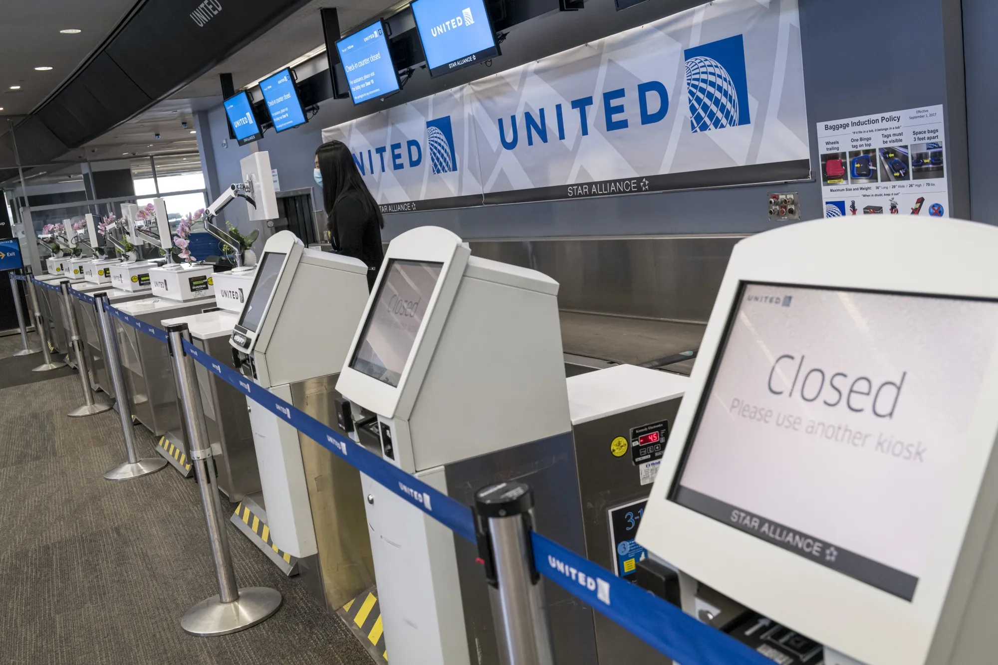 A United Airlines&nbsp;employee waits for a traveler at San Francisco International Airport.