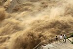 People view water gushing out of Sanmenxia Dam in Sanmenxia city, central China’s Henan province on June 30.
