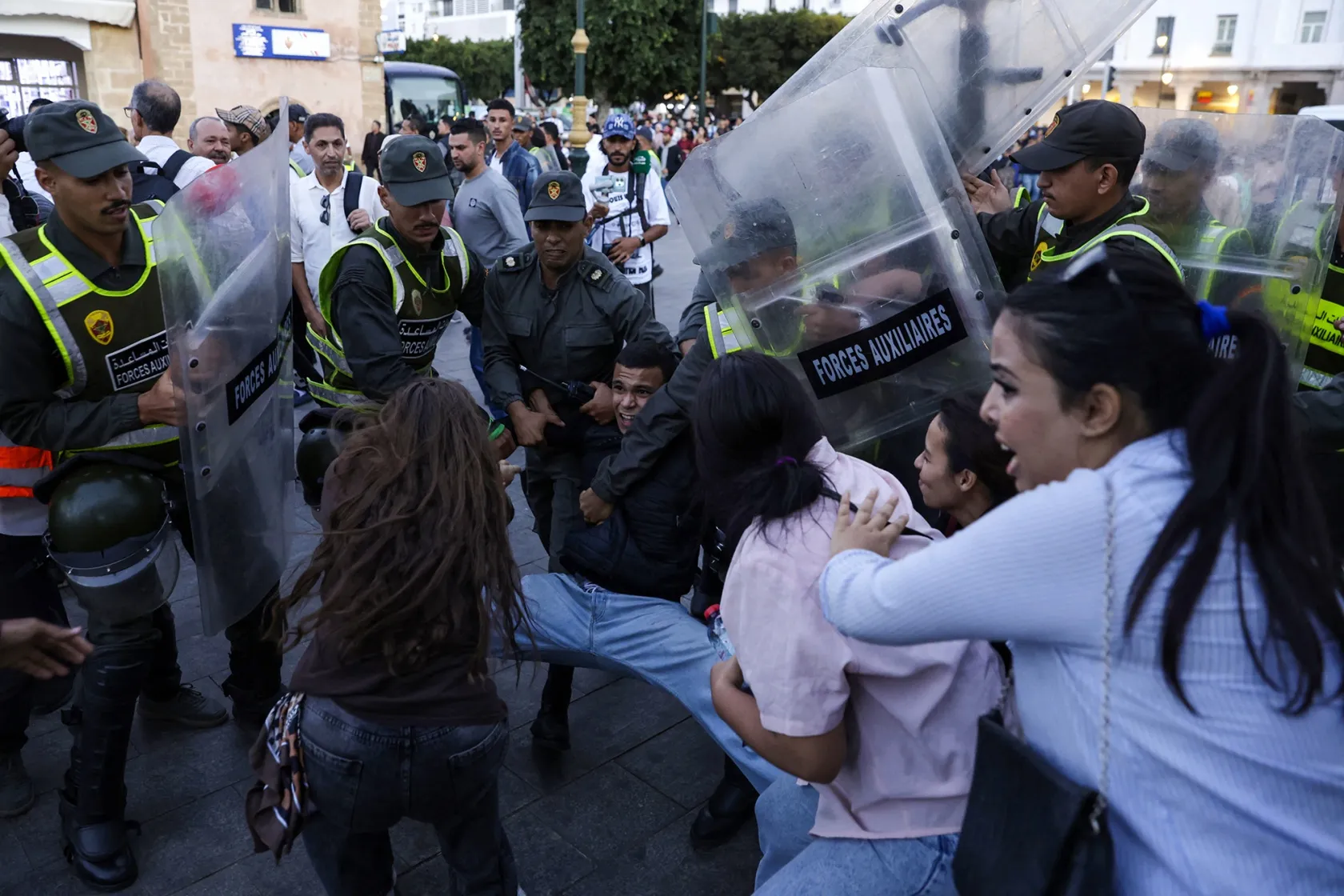 Members of the security forces detain a protester as others scuffle during a youth-led demonstration in Rabat on Sept. 29.&nbsp;