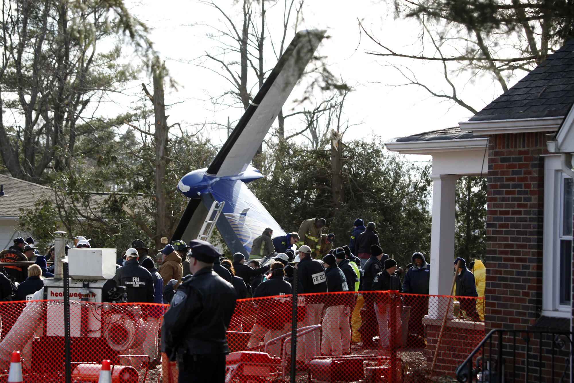 Workers and investigators clear debris from the scene of the crash on Feb. 16, 2009.