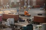 Trucks pulling containers and empty chassis at the Port of Los Angeles.