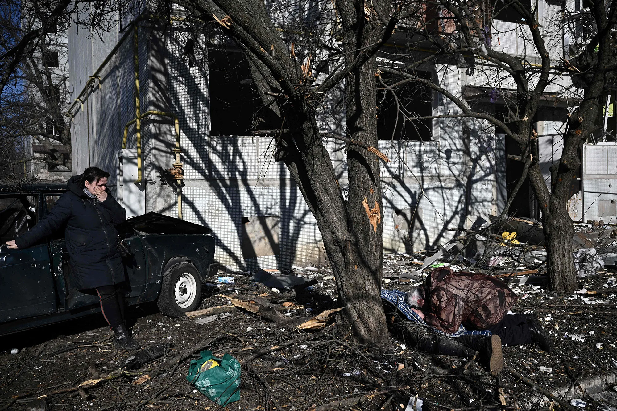 A man mourns over the body of a victim in Russian bombings of the eastern Ukraine town of Chuguiv on Feb. 24.