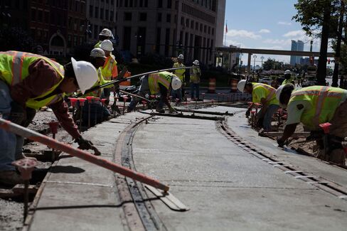 Workers put the finishing touches on a section of the M-1 Rail line in Detroit during construction in 2015. It was the first public transit project in Detroit to bring together both public and private funding for its construction.