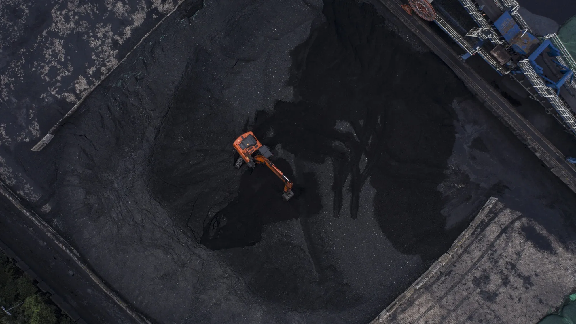 Heavy machinery operates at a coal stockpile in Taicang, China.