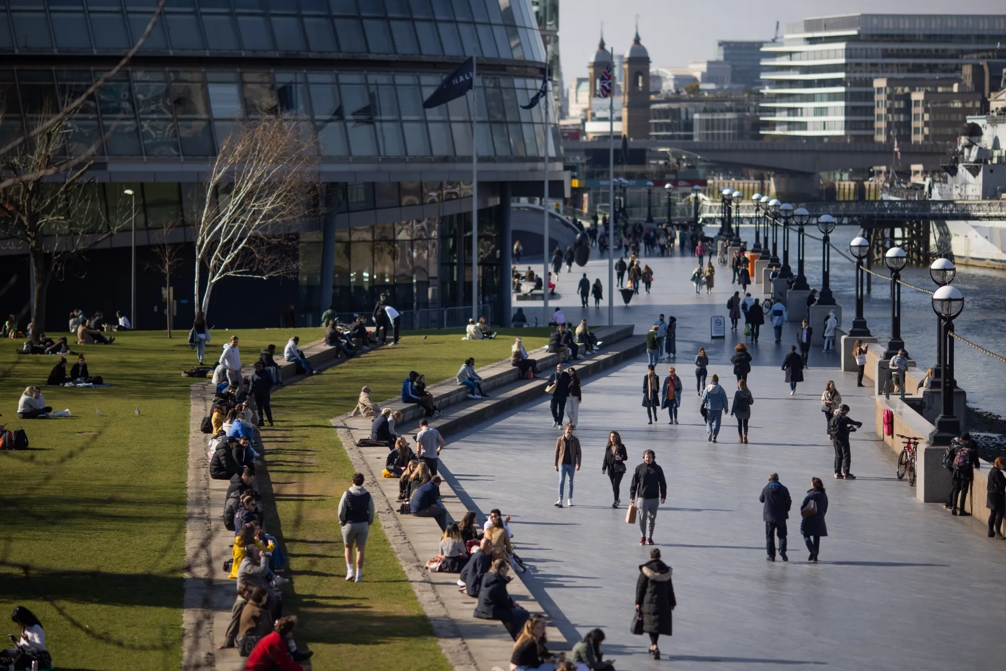 Pedestrians walk along the south bank of the River Thames in London, on March 22.