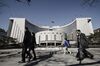 Pedestrians walk past the People's Bank of China headquarters in Beijing.