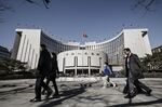 Pedestrians walk past the People's Bank of China headquarters in Beijing.