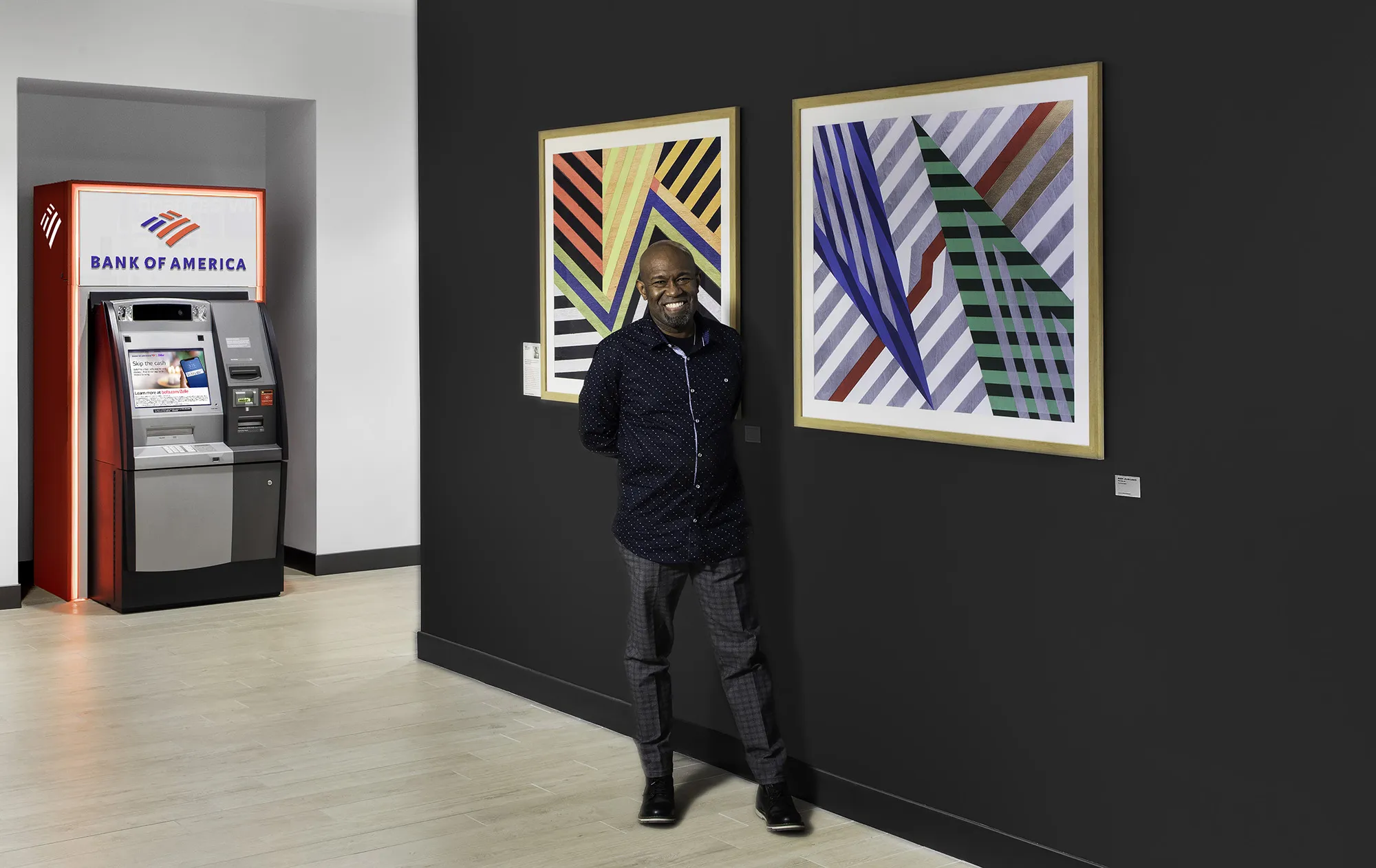 Artist Rudy Jean-Louis poses with artwork at Bank of America’s financial center in New York.
