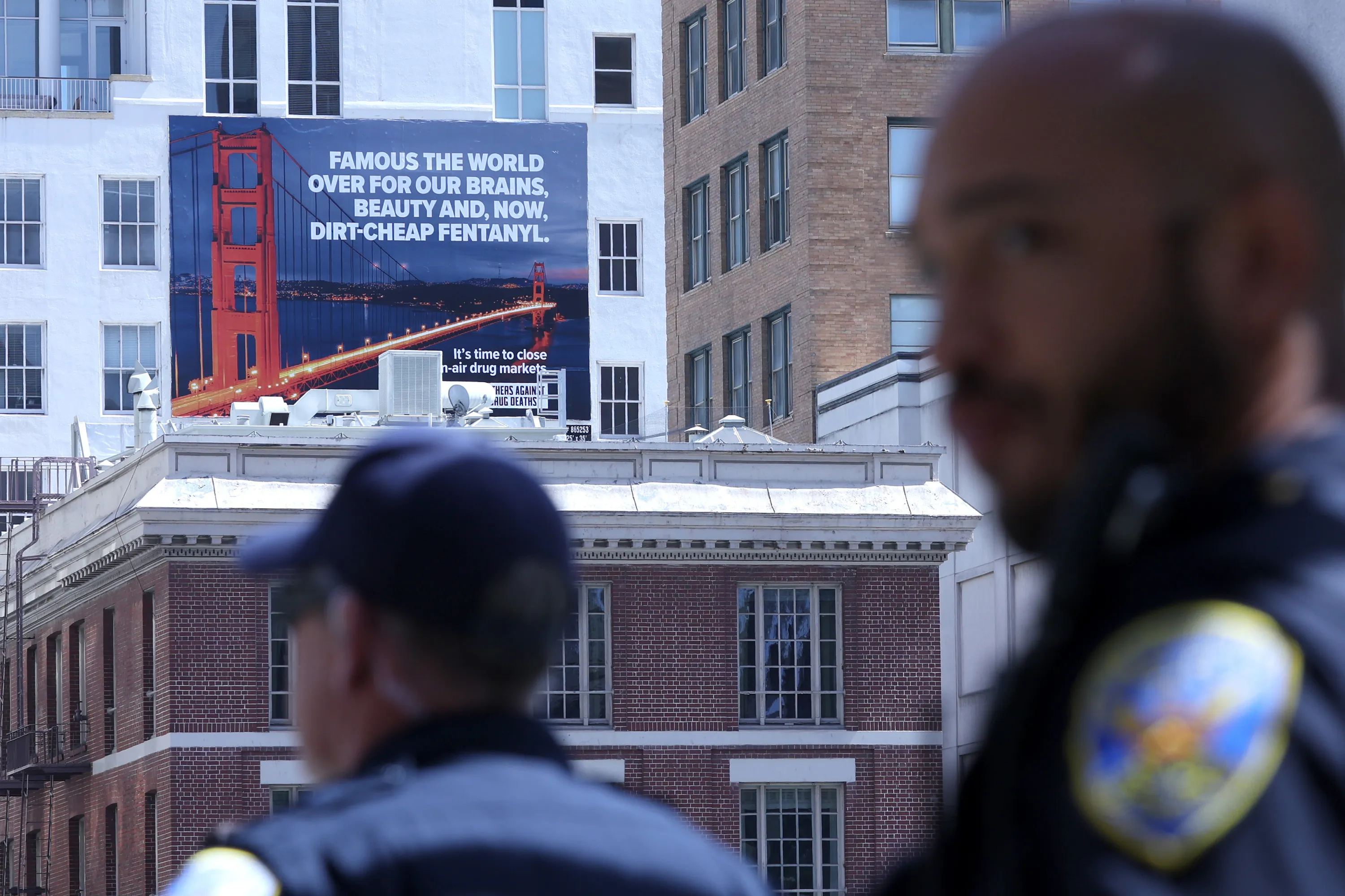 San Francisco police officers look on near a new controversial billboard that warns against fentanyl in San Francisco on April 04, 2022.