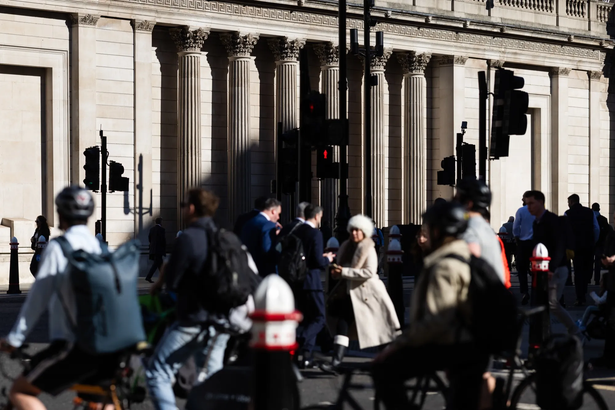 Commuters pass the Bank of England (BOE) in the City of London.