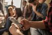 Close up of unrecognizable student using cell phone on a break in the classroom.