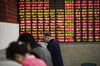 Investors stand at trading terminals in front of electronic stock boards at a securities brokerage in Shanghai, China, on Friday, Oct. 13, 2017. A number of economic indicators show "stabilized and stronger growth" and the momentum of a 6.9 percent expansion in the first six months of 2017 "may continue in the second half," People's Bank of China Governor Zhou Xiaochuan said.
