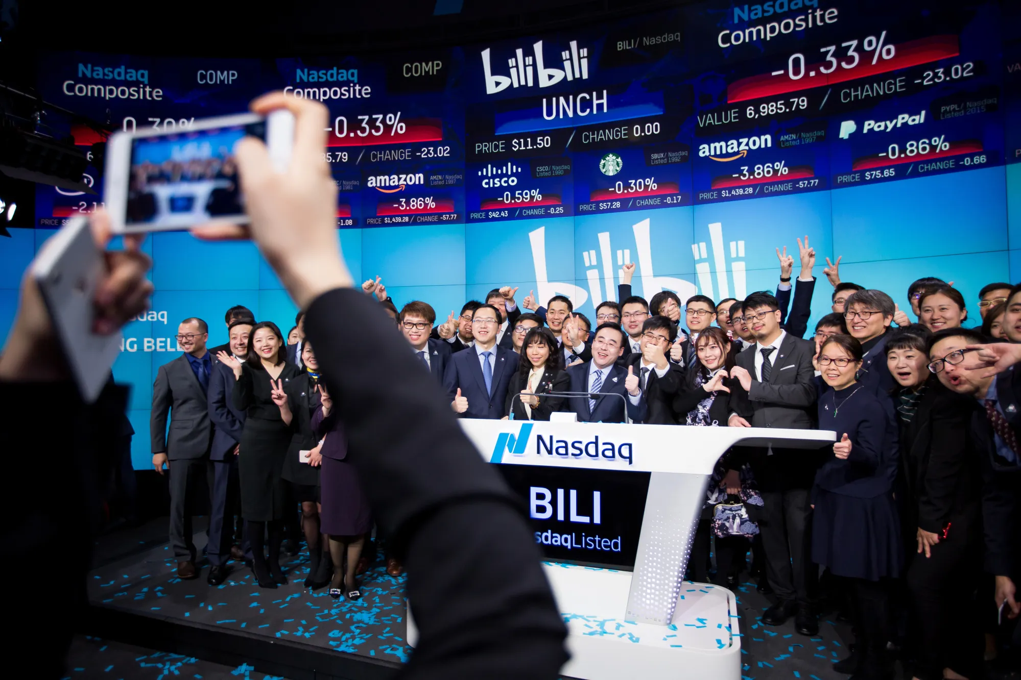 Rui Chen, chairman and chief executive officer of Bilibili Inc., center, stands for a photograph with employees during the company's initial public offering (IPO) at the Nasdaq MarketSite in New York.
