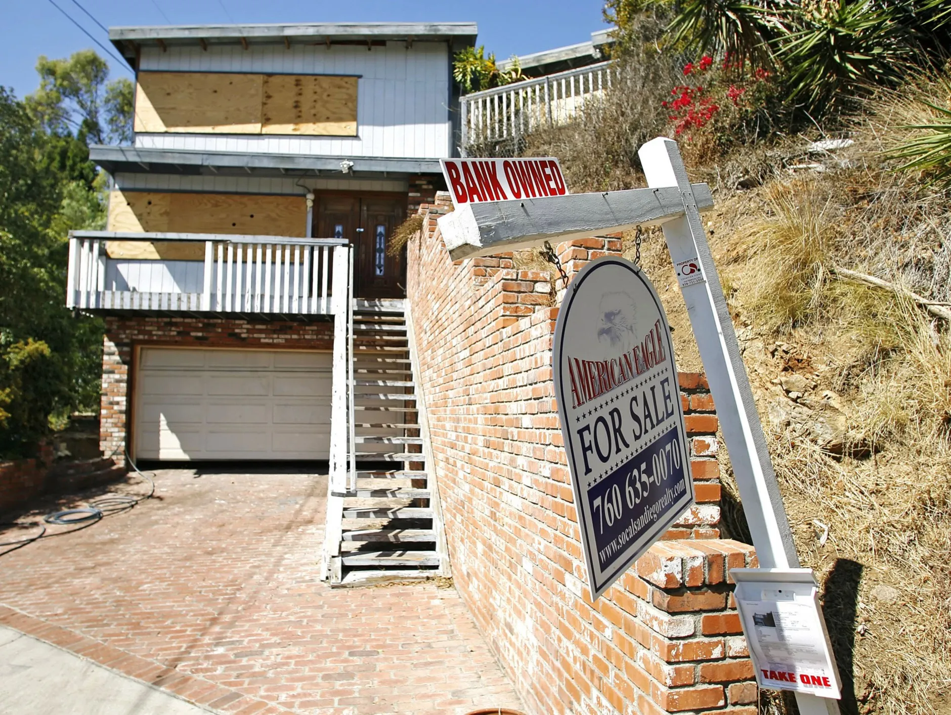 A bank owns this boarded up home in a residential La Mesa, California, neighborhood that has been for sale for some time.