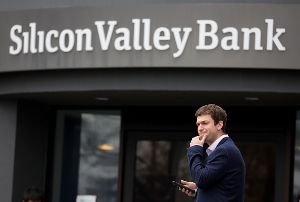 SANTA CLARA, CALIFORNIA - MARCH 10: A customer stands outside of a shuttered Silicon Valley Bank (SVB) headquarters on March 10, 2023 in Santa Clara, California. Silicon Valley Bank was shut down on Friday morning by California regulators and was put in control of the U.S. Federal Deposit Insurance Corporation. Prior to being shut down by regulators, shares of SVB were halted Friday morning after falling more than 60% in premarket trading following a 60% declined on Thursday when the bank sold off a portfolio of US Treasuries and $1.75 billion in shares to cover declining customer deposits. (Photo by Justin Sullivan/Getty Images)