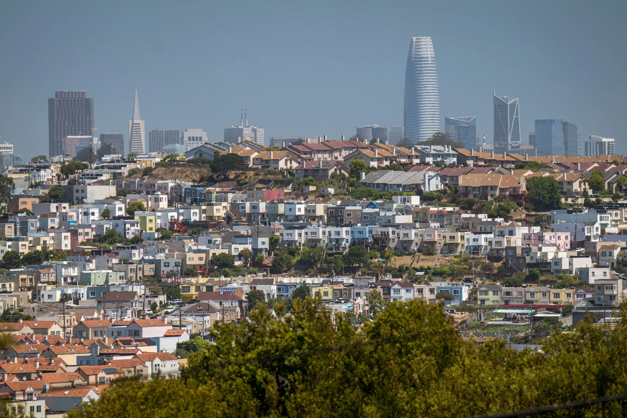 Homes stand in front of the San Francisco skyline in San Francisco, California.